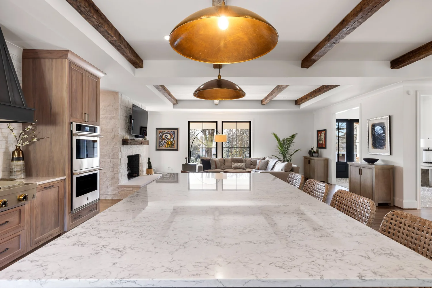 Open concept kitchen and living space with exposed beams